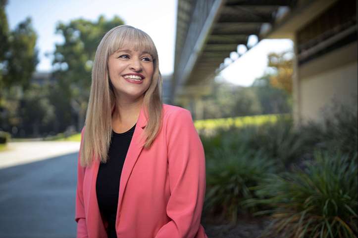 An SCE employee outside smiling at camera right