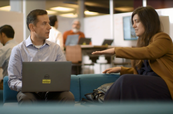 A woman and a man talking to man while sitting down