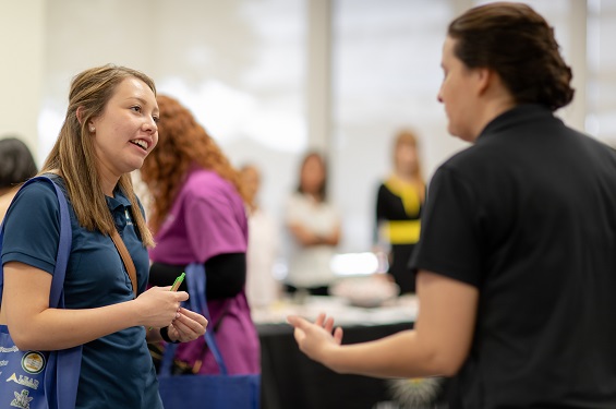 Two women talking in a fair setting