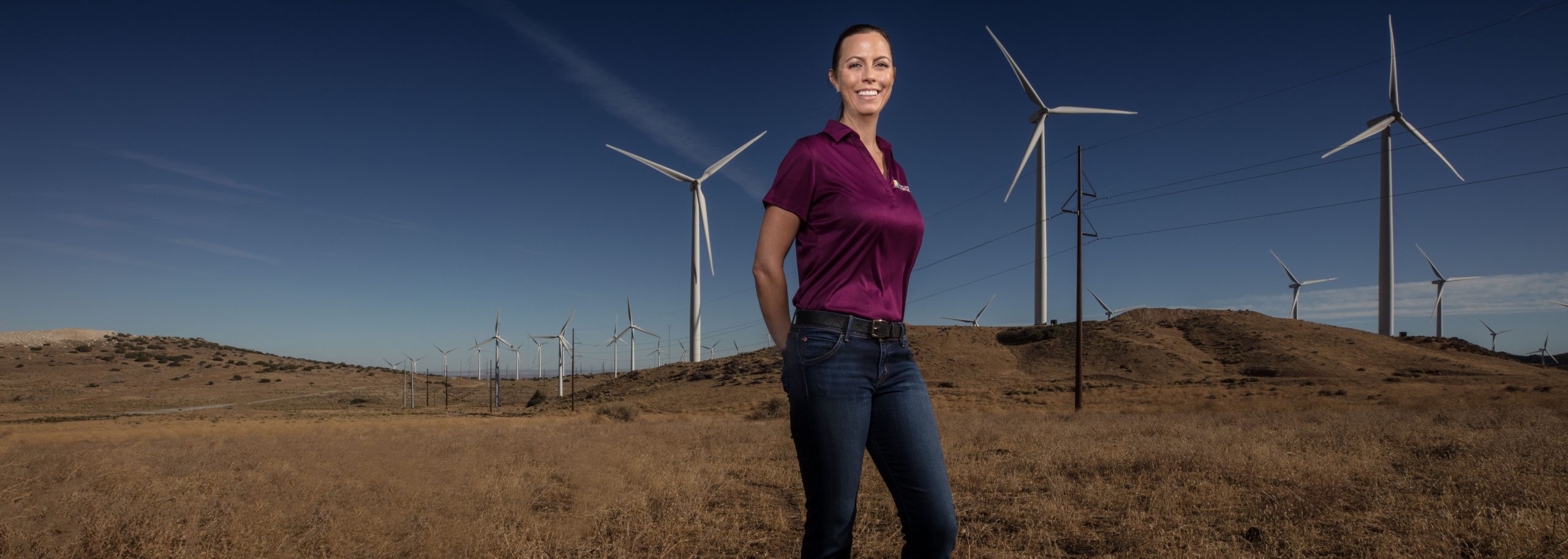 A woman standing and smiling and looking into the camera