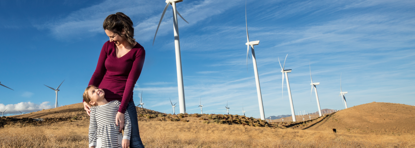 A smiling woman holding and looking at a child