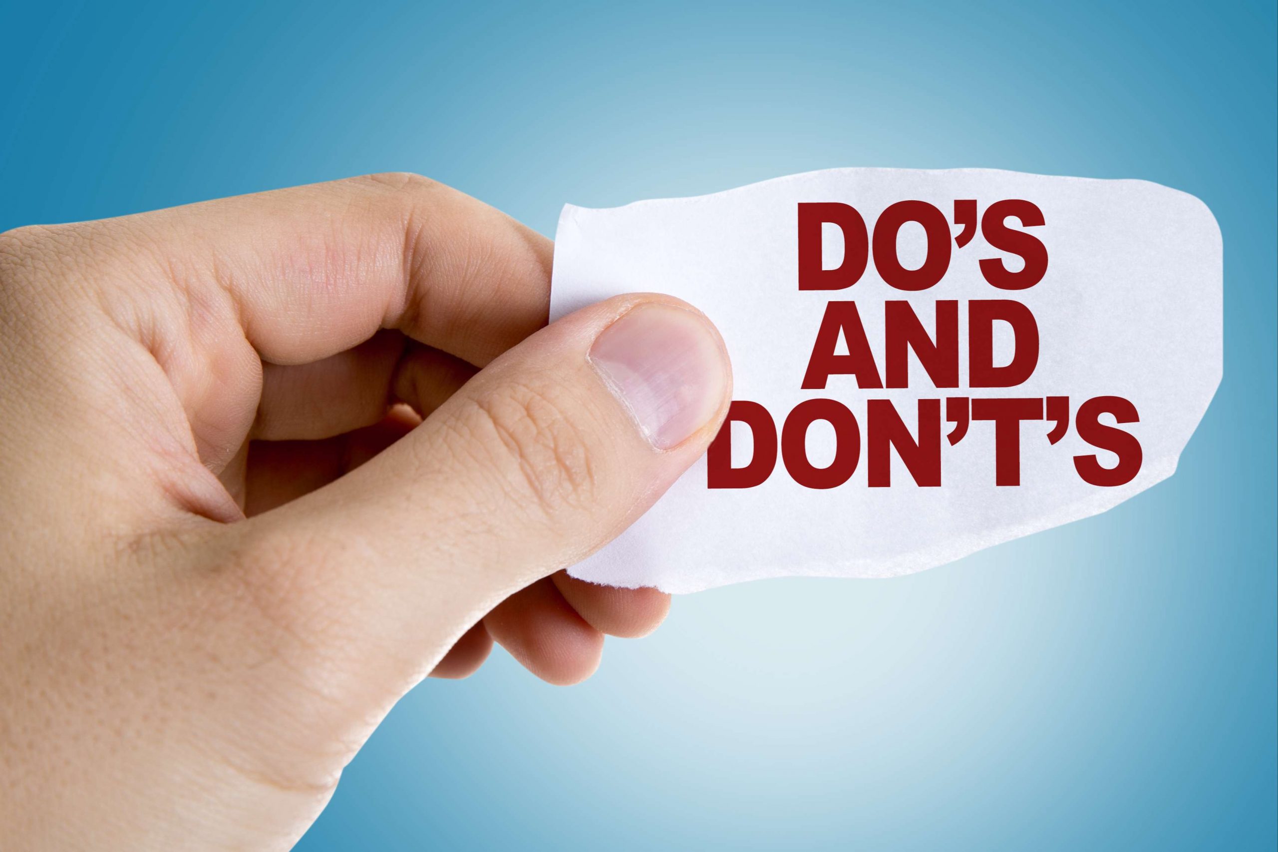 Someone holding a paper that says do's and don'ts