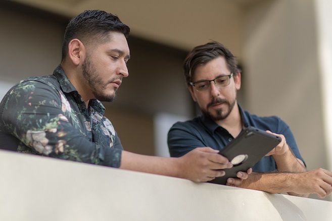 Two men looking at an ipad