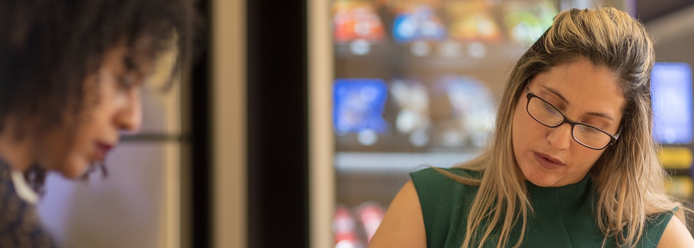 2 women working together looking down at their work