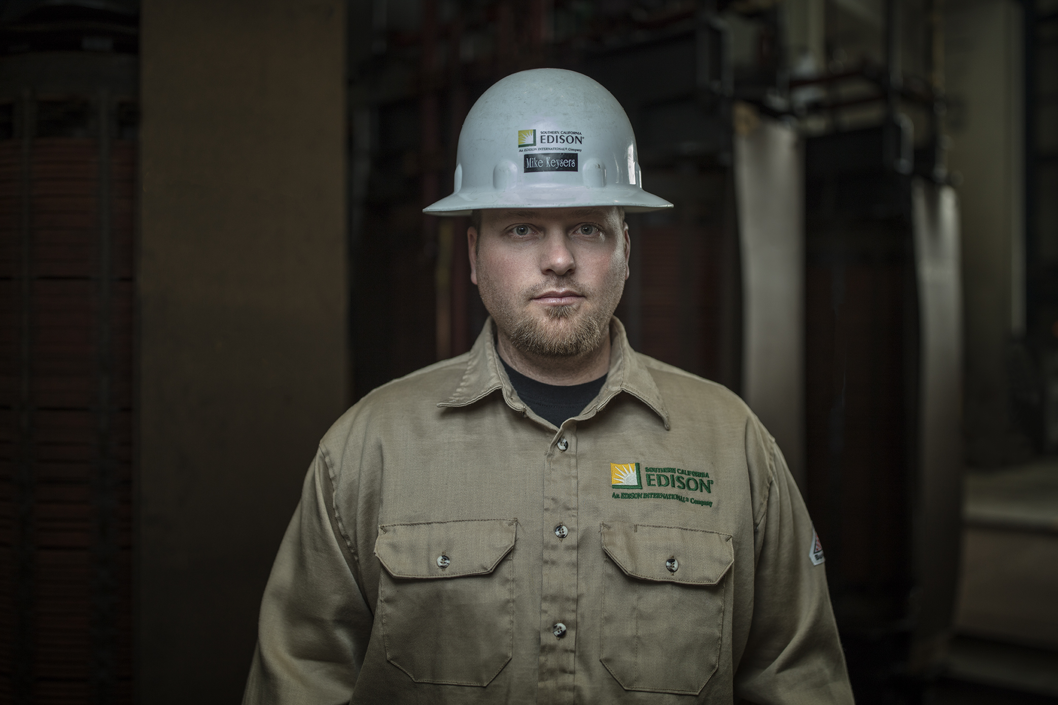 A man wearing a hardhat and an Edison shirt smiling at the camera