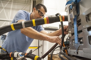 A technician fixing a wire in a substation