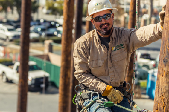 A lineman wearing a hard hat looking at the camera