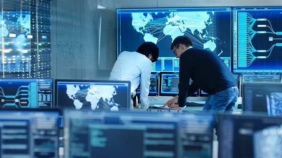 Two men talking in front of a computer