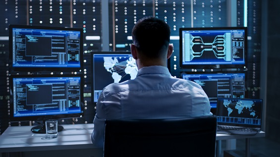 A man facing multiple computer screens