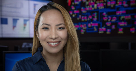 A smiling woman with a grid board in the background